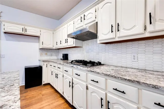 a kitchen with stainless steel appliances granite countertop a sink and a stove