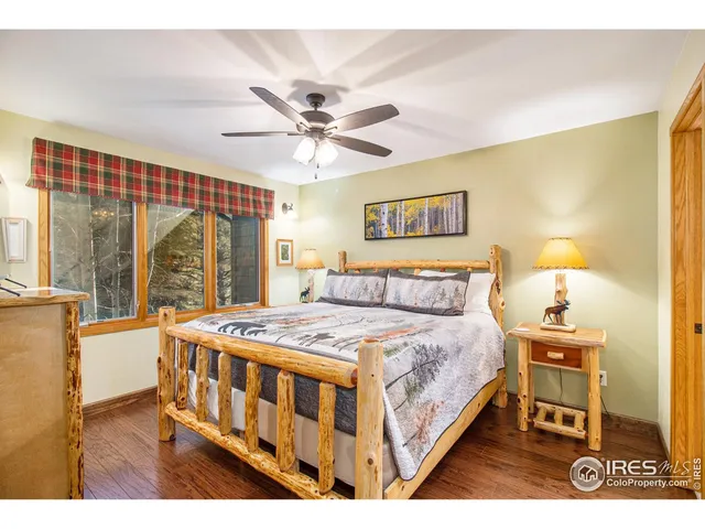 a bedroom with a bed a chandelier and next to a window