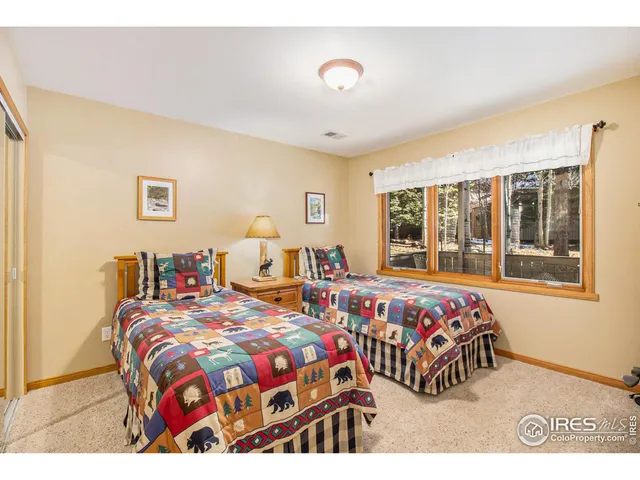 a bedroom with two beds and a large window