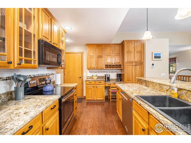 a kitchen with stainless steel appliances granite countertop a sink a stove and a refrigerator