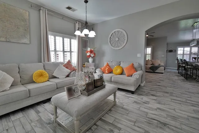 a kitchen with cabinets a counter space stainless steel appliances and a chandelier
