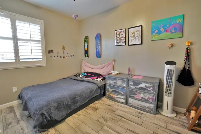 a bedroom with a bed and wooden floor