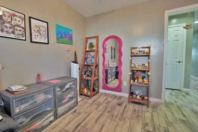 a bedroom with bed and wooden floor