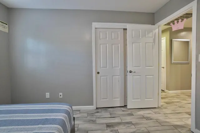 a view of a bedroom with closet and mirror