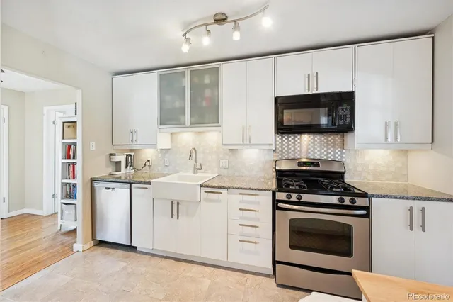 a kitchen with stainless steel appliances granite countertop a stove a sink and a microwave