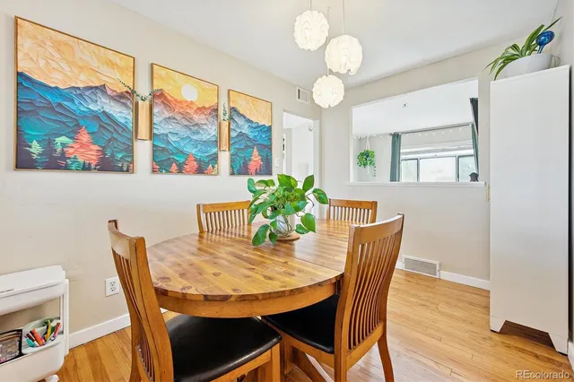 a view of a dining room with furniture a chandelier and wooden floor