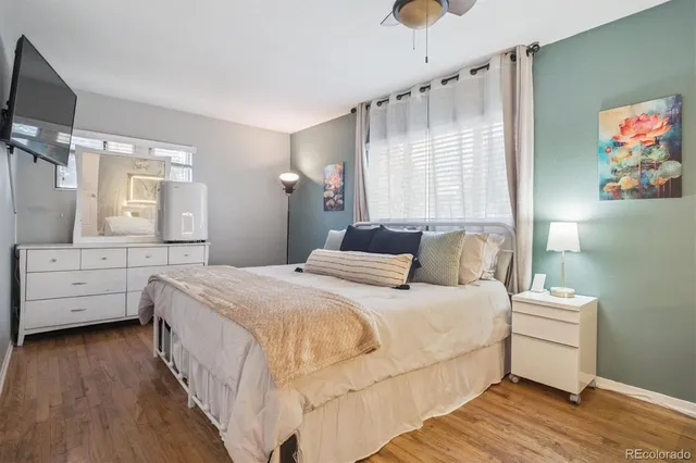 a bedroom with a bed a flat screen tv and dresser