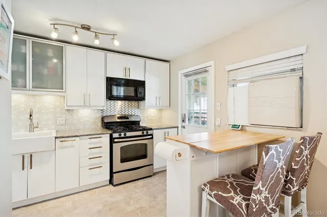 a kitchen with kitchen island granite countertop a sink a stove and cabinets