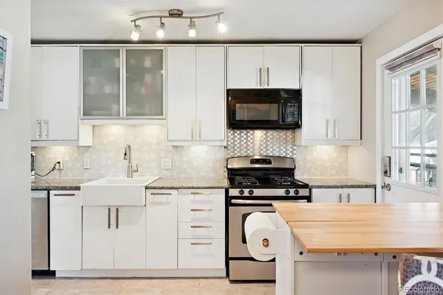 a kitchen with stainless steel appliances a sink and a refrigerator