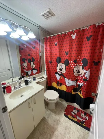 a bathroom with a sink mirror vanity and toilet