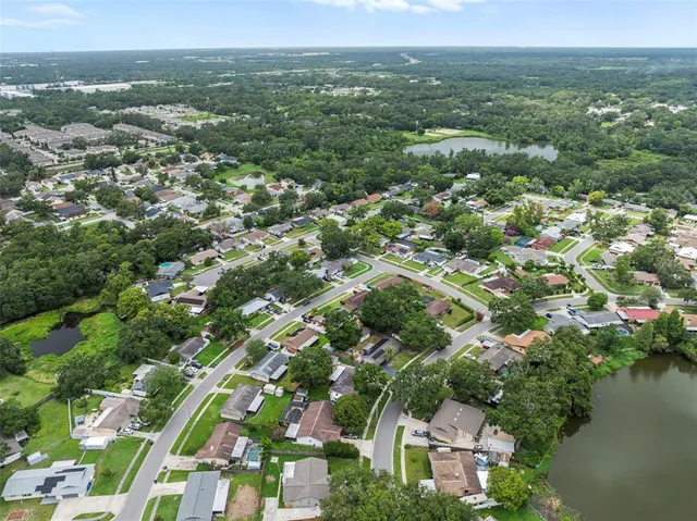 an aerial view of residential houses with outdoor space and lake view