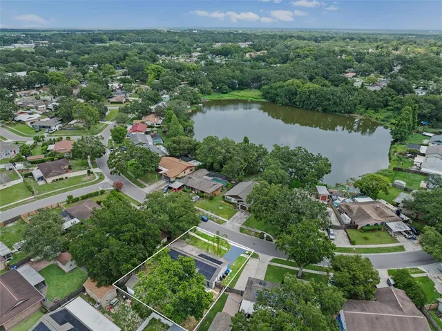 an aerial view of lake residential house with outdoor space and trees all around
