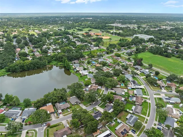 an aerial view of residential houses with outdoor space and lake view