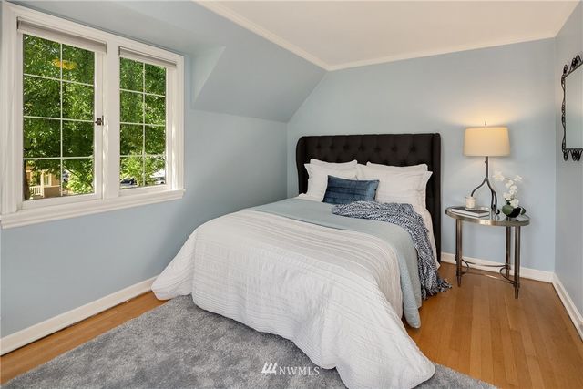 a bedroom with a bed table chair and a window