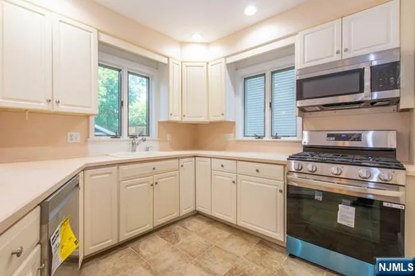 a kitchen with cabinets stainless steel appliances and a sink