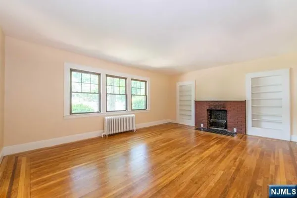 wooden floor fireplace and windows in an empty room