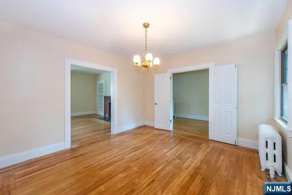 a view of a room with wooden floor and chandelier