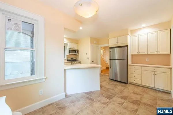 a kitchen with white cabinets and refrigerator