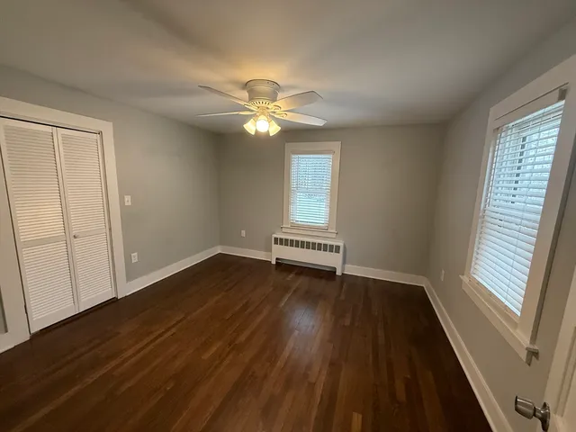 a view of a room with wooden floor and a window