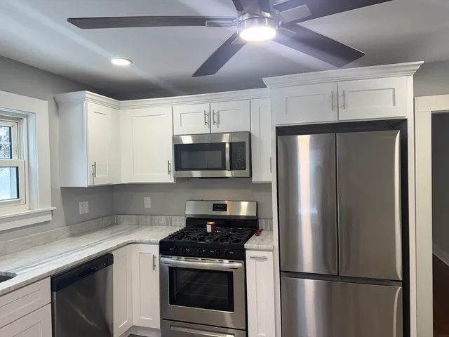 a kitchen with stainless steel appliances a refrigerator a stove a microwave oven cabinets and a refrigerator