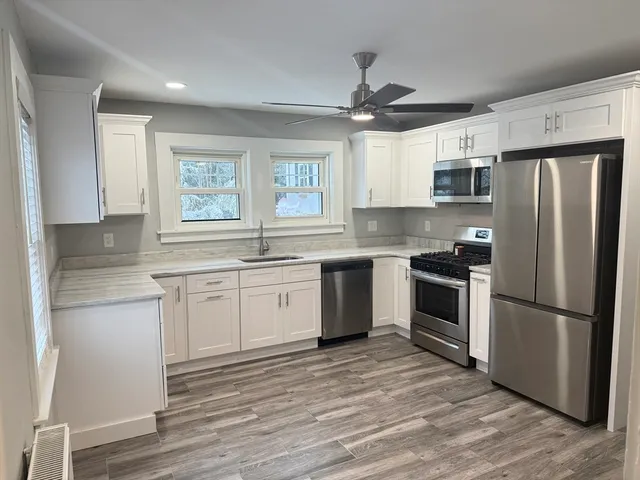 a kitchen with granite countertop a refrigerator stove and oven