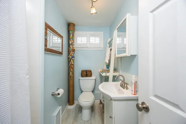 a bathroom with a sink toilet and a mirror