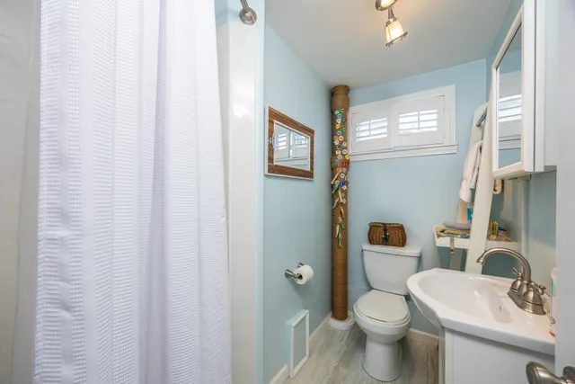 a bathroom with a toilet a sink and a window