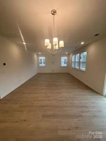 a view of a big room with windows and chandelier