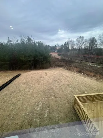 a view of swimming pool with seating area and trees in the background