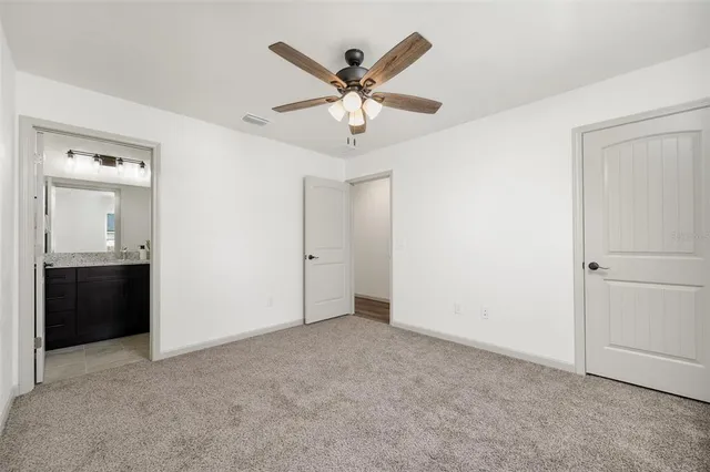 a view of an empty room with a ceiling fan