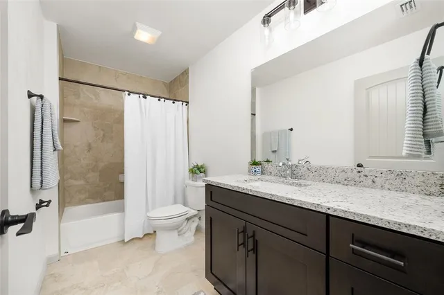 a bathroom with a granite countertop sink toilet and shower