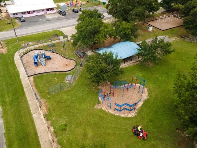 an aerial view of a pool a yard and mountain view in back