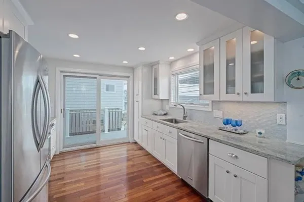 a large kitchen with a sink stainless steel appliances and cabinets