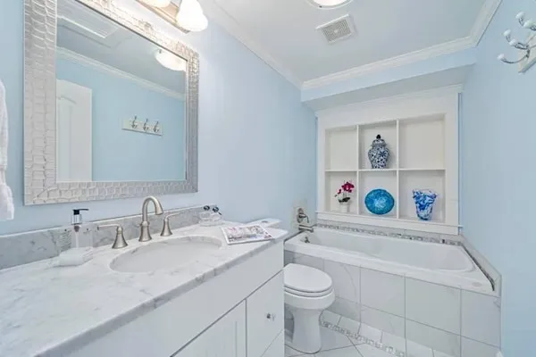 a bathroom with a granite countertop sink mirror and toilet