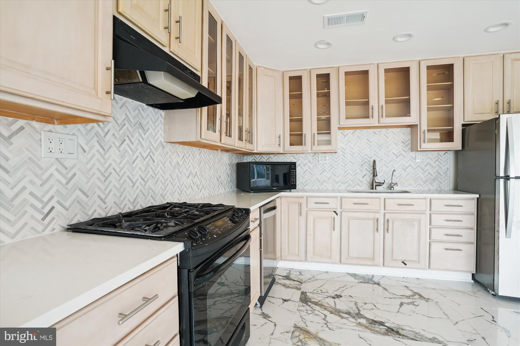 3143 Calvert Boulevard Lusby, MD 20657 - Photo 25 of 36 a kitchen with granite countertop a stove sink and cabinets