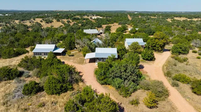a view of a house with a small yard and a large tree