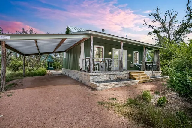 a porch with a bench next to a yard
