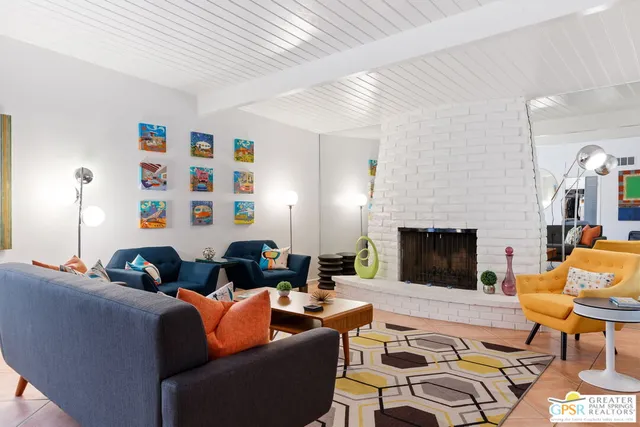 a living room with furniture fireplace and a large window