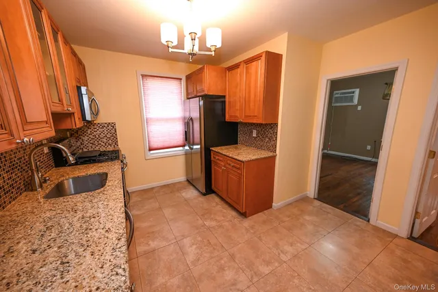 a kitchen with stainless steel appliances granite countertop sink stove and refrigerator