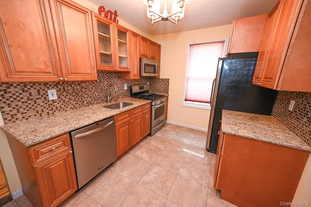 a kitchen with stainless steel appliances granite countertop a stove a sink and a refrigerator