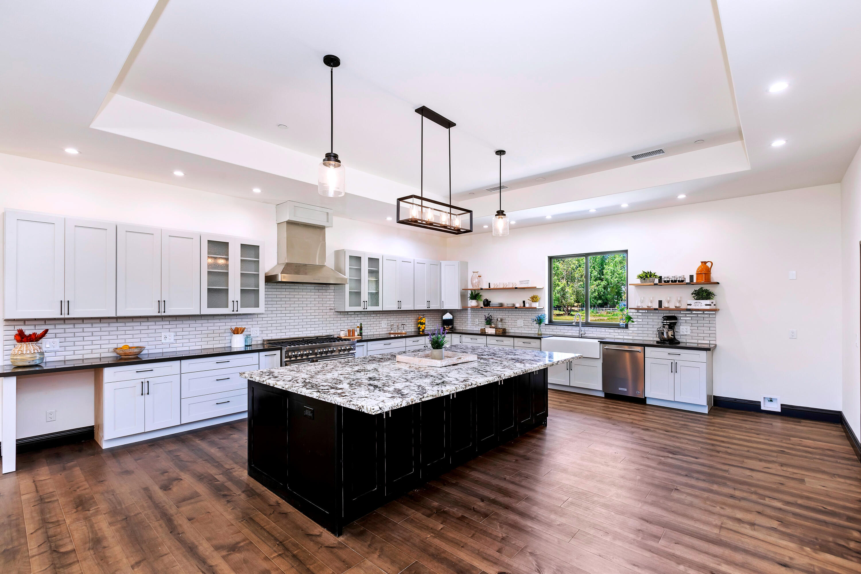 17370 Rodeo Road Lake Elsinore, CA 92530 - Photo 28 of 68 a large kitchen with stainless steel appliances kitchen island granite countertop a large counter top a sink dishwasher a stove and a refrigerator with wooden floor