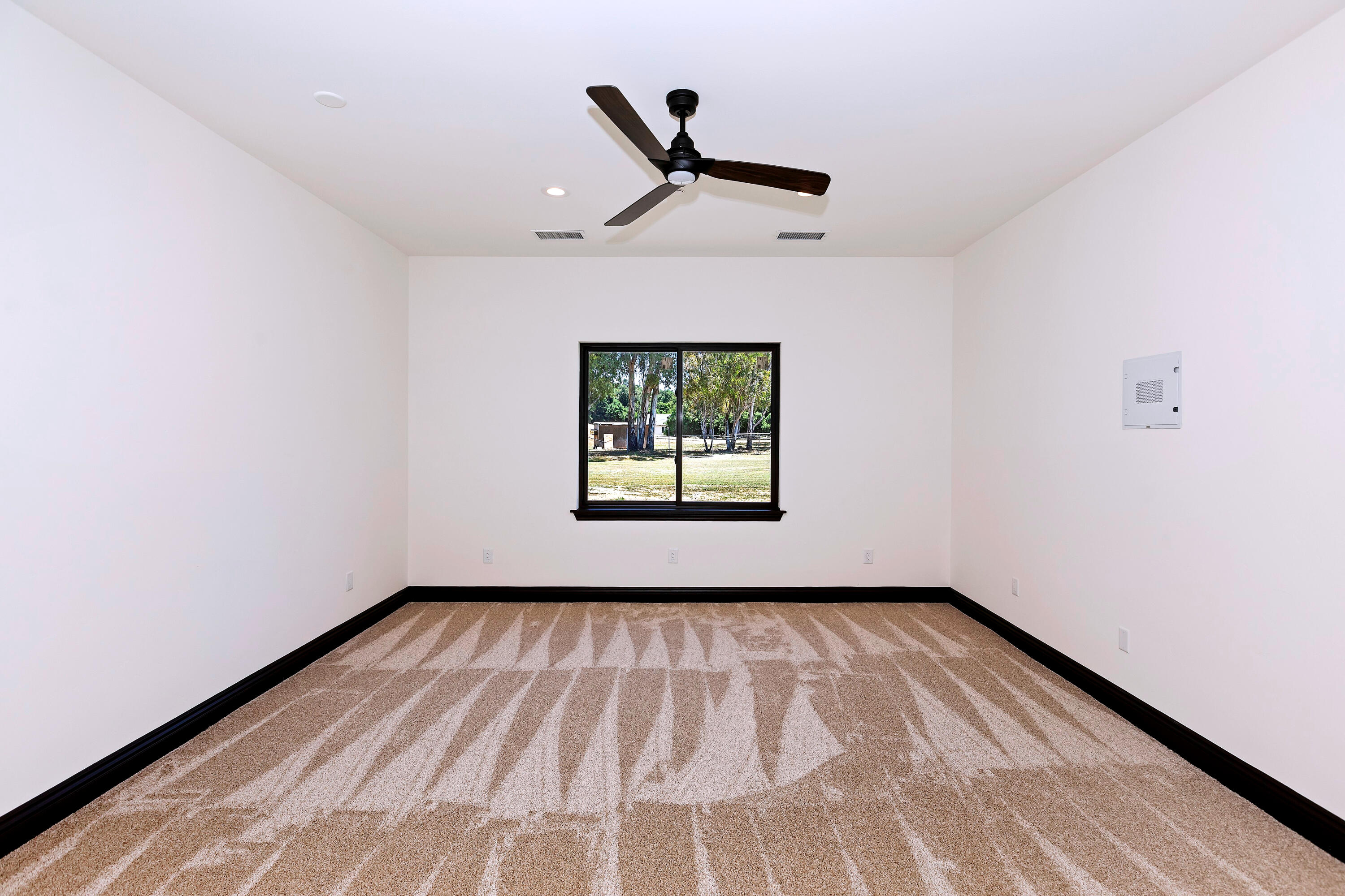 17370 Rodeo Road Lake Elsinore, CA 92530 - Photo 42 of 68 a view of a room with wooden floor a ceiling fan and a window