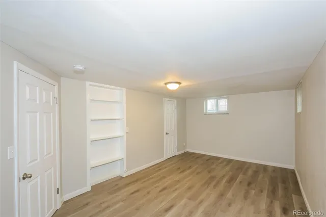 a view of empty room with wooden floor