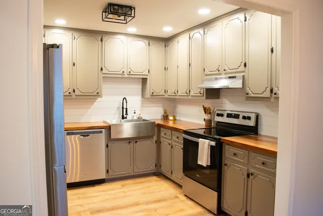 a kitchen with stainless steel appliances granite countertop a refrigerator and a sink