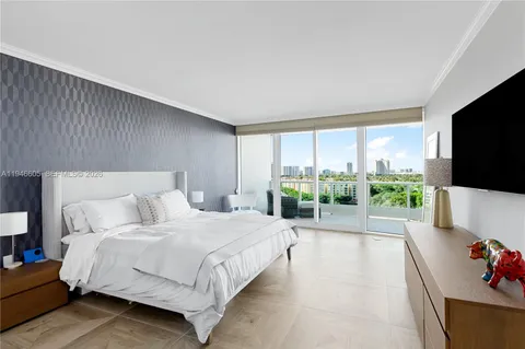 a large bedroom with a bed and large window