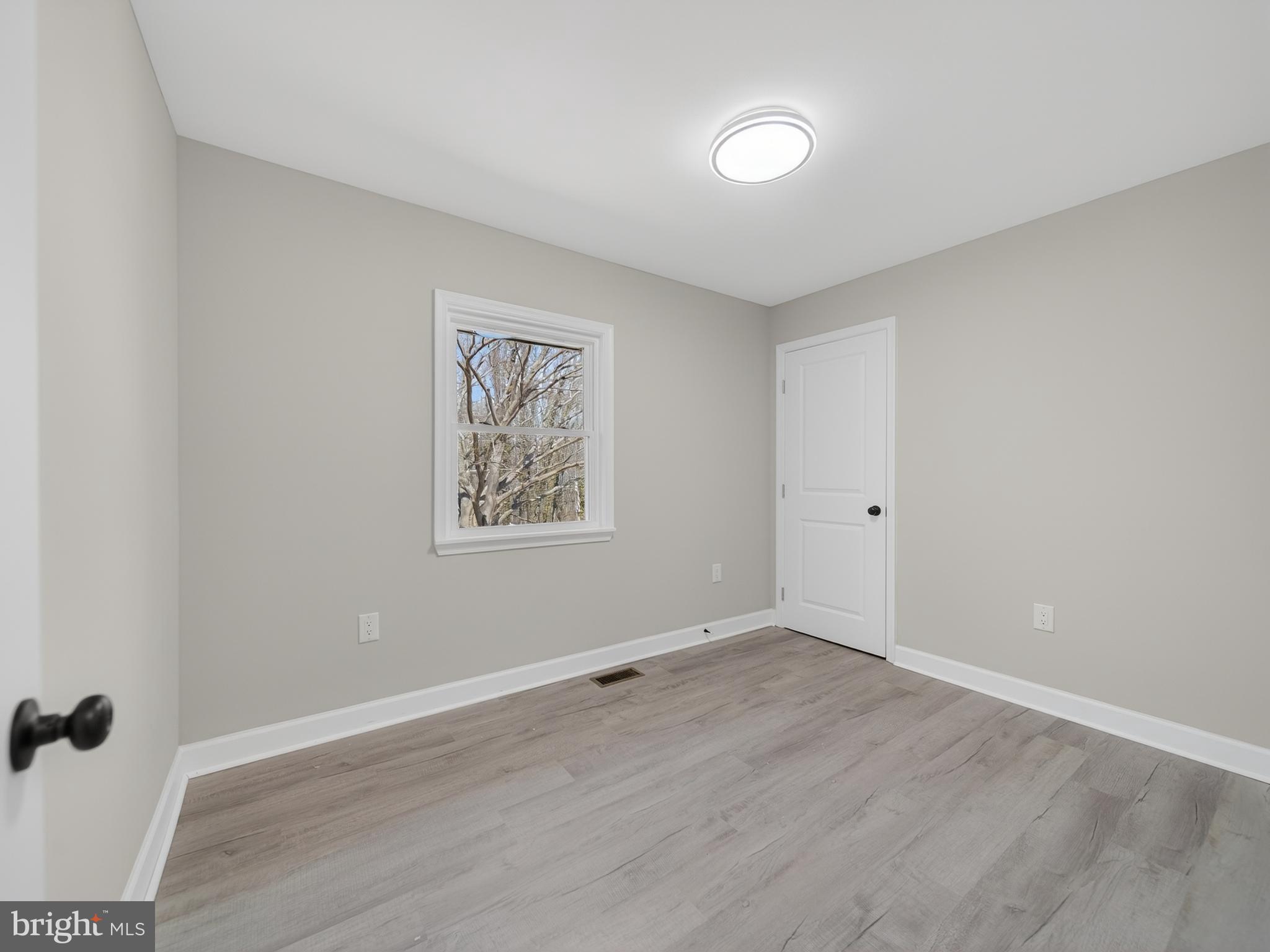 4475 Virginia Avenue Prince Frederick, MD 20678 - Photo 30 of 51 an empty room with wooden floor and windows