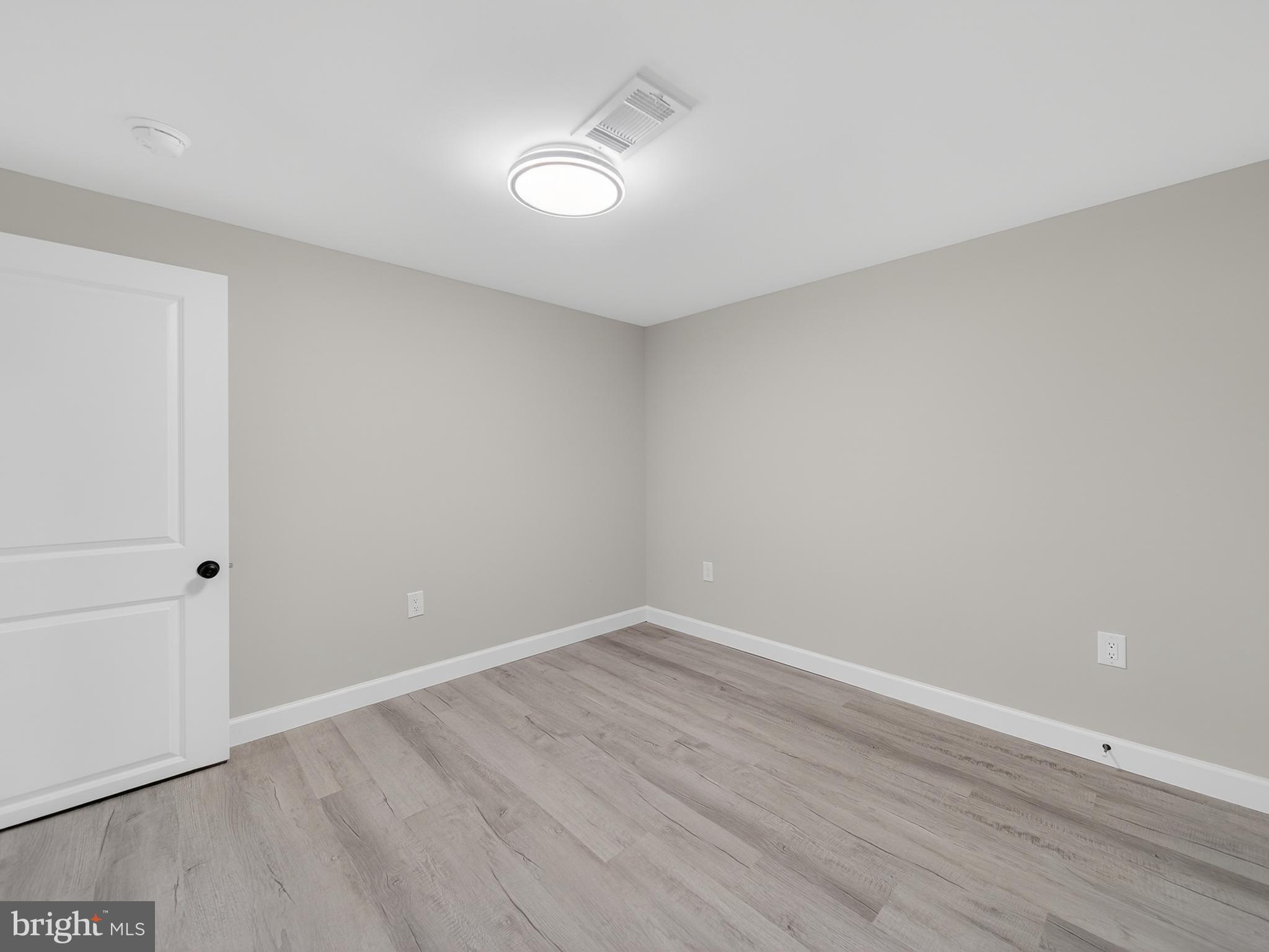 4475 Virginia Avenue Prince Frederick, MD 20678 - Photo 41 of 51 a view of an empty room with wooden floor and a window