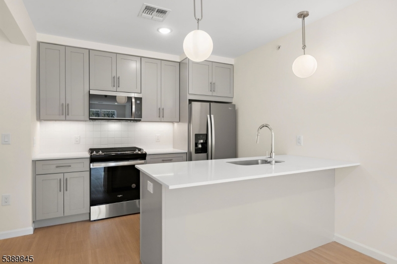 70 Ridgedale Avenue, Unit 310 Morristown, NJ 07960 - Photo 3 of 21 a kitchen with stainless steel appliances granite countertop a sink a stove a refrigerator a center island with wooden floor