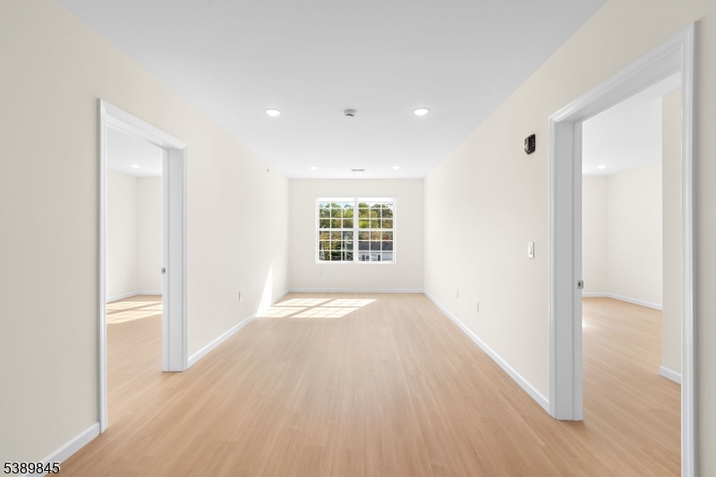 70 Ridgedale Avenue, Unit 310 Morristown, NJ 07960 - Photo 4 of 21 a view of an empty room with wooden floor and a window