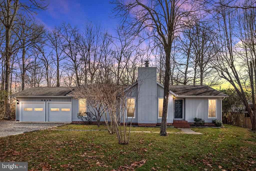 a big tree in front of a brick house